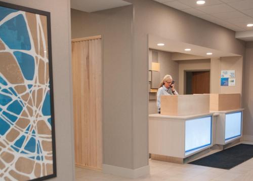 a person standing at a reception desk in an office at Holiday Inn Express Hotel & Suites Norfolk by IHG in Norfolk