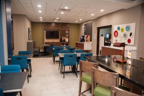 a restaurant with tables and chairs and a cafeteria at Holiday Inn Express Hotel & Suites Norfolk by IHG in Norfolk