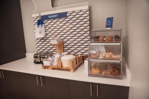 a bakery counter with donuts and other items on it at Holiday Inn Express Hotel & Suites Norfolk by IHG in Norfolk