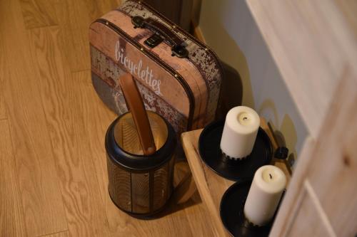 a suitcase and two candles on a wooden table at Sistò Petite Maison in Altamura