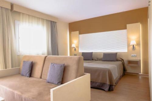 マスパロマスにあるHL Suite Nardos - Only Adultsのベッド2台とソファが備わるホテルルームです。