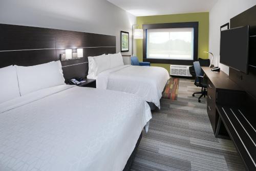 a hotel room with two beds and a television at Holiday Inn Express & Suites Bryan - College Station by IHG in Bryan