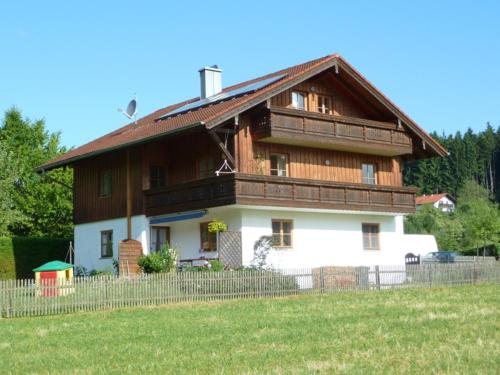 a large wooden house with a fence in front of it at Ferienwohnung Holzmaier in Bad Aibling