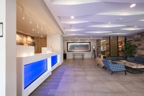 an office lobby with a reception desk and a couch at Holiday Inn Express and Suites Celaya by IHG in Celaya