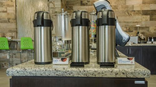 a counter with two silver thermos on top of it at Holiday Inn Express and Suites Celaya by IHG in Celaya