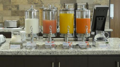 a counter with four glass containers of different types of juice at Holiday Inn Express and Suites Celaya by IHG in Celaya
