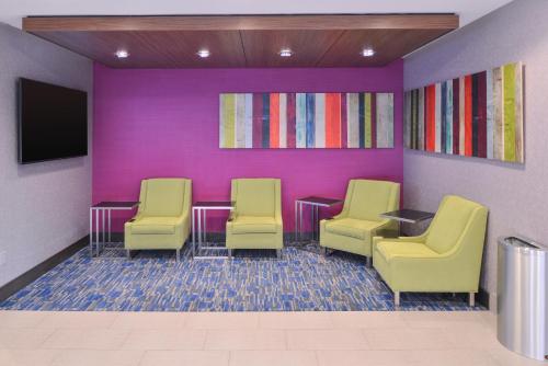 a waiting room with three chairs and a tv at Holiday Inn Express and Suites Bryant - Benton Area by IHG in Bryant