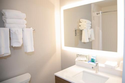 a bathroom with a sink and a mirror and towels at Holiday Inn Express & Suites Colorado Springs North by IHG in Colorado Springs