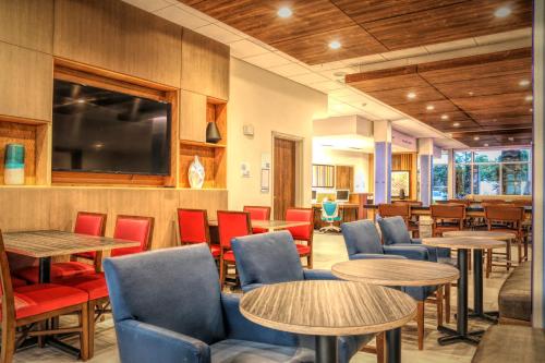 a restaurant with tables and chairs and a tv at Holiday Inn Express & Suites - Chalmette - New Orleans S by IHG in Chalmette