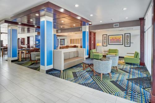 a lobby with chairs and a couch and tables at Holiday Inn Express & Suites El Paso East-Loop 375 by IHG in El Paso