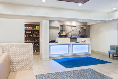 two people standing at a counter in a dental office at Holiday Inn Express & Suites - Columbus Airport East by IHG in Columbus