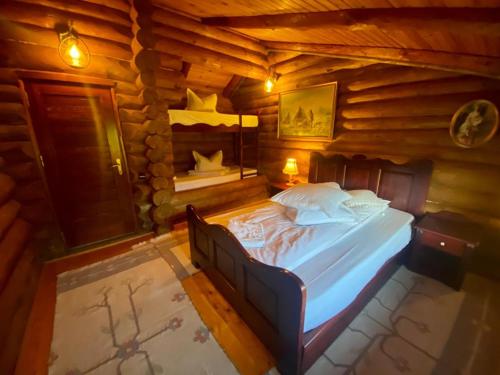 una camera con un letto in una baita di tronchi di Cabana vânătorului a Rîşnov