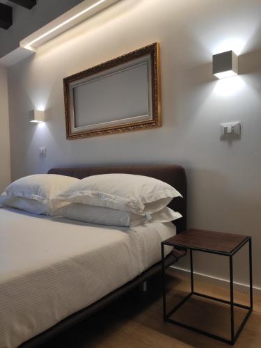 a bedroom with a bed with a mirror and a table at Borgo di Ponte Holiday Apartments & Rooms in Cividale del Friuli