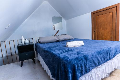 1 dormitorio con cama azul y manta azul en Apartamento Completo de 2 quartos em Gramado, en Gramado