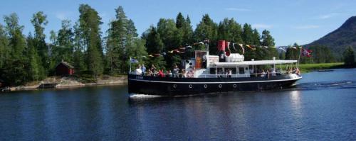 a boat with people on it on the water at Norbel Hytte Norway in Vradal