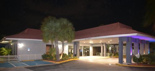 a building with a palm tree in front of it at night at Days Inn by Wyndham Stuart in Stuart