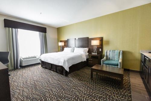 a hotel room with a bed and a chair at Holiday Inn Express & Suites Spruce Grove - Stony Plain by IHG in Spruce Grove