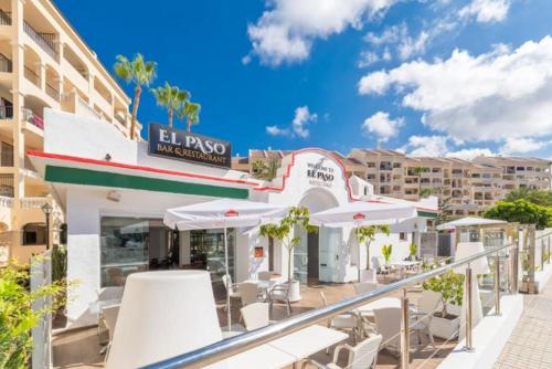 balkon hotelu z krzesłami i parasolami w obiekcie Serena Solvista - Los Cristianos w mieście Los Cristianos