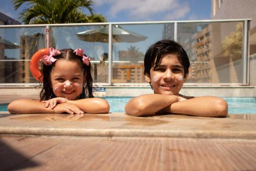 dos chicas jóvenes tumbadas en una piscina en Holiday Inn Express Maceió, an IHG Hotel en Maceió