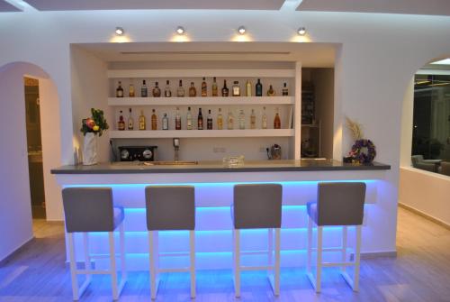 a blue bar with four chairs in a room at Petinaros Hotel in Mýkonos City