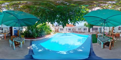 a swimming pool with two umbrellas and chairs at Casa Pancho Playa in San Francisco