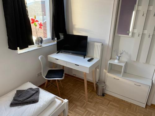 a bedroom with a desk with a television on it at AschaffApartment 4 Schlafzimmer bis 10 Personen bei Aschaffenburg in Mainaschaff