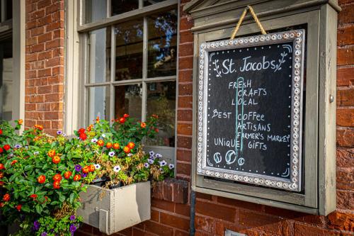 a chalkboard sign on the side of a building with flowers at Staybridge Suites - Waterloo - St. Jacobs Area in Waterloo