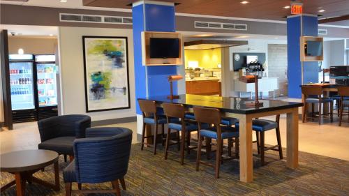 a restaurant with a table and chairs and a kitchen at Holiday Inn Express & Suites - Jacksonville W - I295 and I10 by IHG in Jacksonville