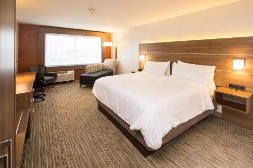 a hotel room with a large bed and a desk at Holiday Inn Express & Suites - Kalamazoo West by IHG in Kalamazoo