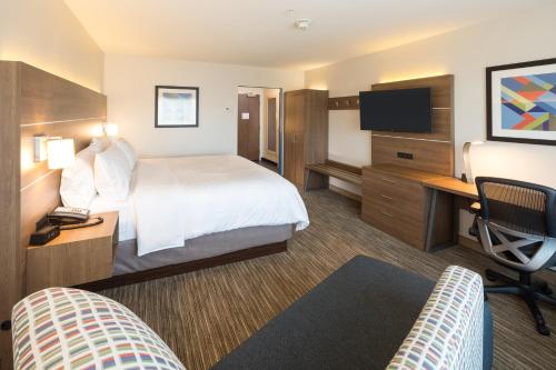 a hotel room with a bed and a desk and a tv at Holiday Inn Express & Suites - Kalamazoo West by IHG in Kalamazoo