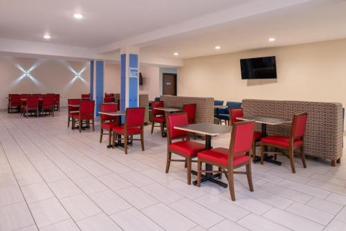 a dining room with tables and red chairs at Holiday Inn Express Hotel & Suites Gunnison by IHG in Gunnison