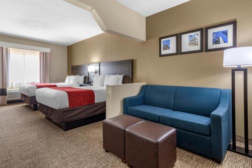 a hotel room with two beds and a blue couch at Comfort Suites near Robins Air Force Base in Warner Robins