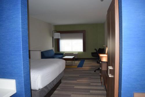 a hotel room with a bed and a chair and a desk at Holiday Inn Express & Suites Ithaca by IHG in Ithaca