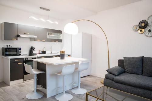 a kitchen and living room with a table and a couch at *Le Tendance appart* in Village-Neuf