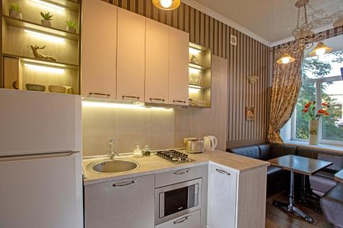 a kitchen with a refrigerator, sink, and dishwasher at City Garden Apartments in Odesa