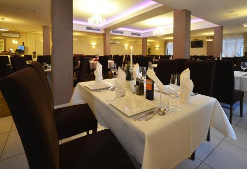 a dining room with a white table with wine glasses at Hotel Camelot in Szczawno-Zdrój