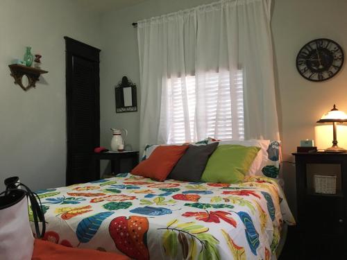 een slaapkamer met een bed met een kleurrijk dekbed bij The Jewel of Little Havana - 2S in Miami