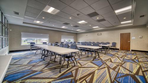 a conference room with tables and chairs on a rug at Holiday Inn Express & Suites - Kokomo South by IHG in Kokomo