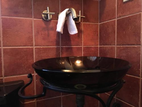 een badkamer met een zwarte wastafel en een handdoek bij The Jewel of Little Havana - 2S in Miami
