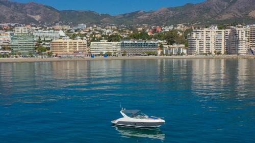a boat in the water in front of a city at Vegasol Playa A.T in Fuengirola