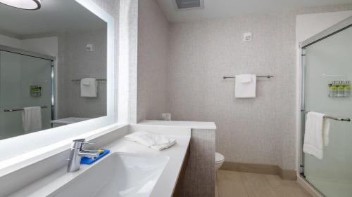 a bathroom with a tub and a sink and a mirror at Holiday Inn Express & Suites - Marion by IHG in Marion