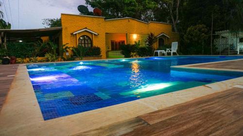 a swimming pool with blue water in front of a house at Eco Hostal Kuima in El Zaino