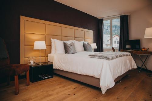 sypialnia z dużym białym łóżkiem i oknem w obiekcie Hotel Dakota w mieście Meiringen
