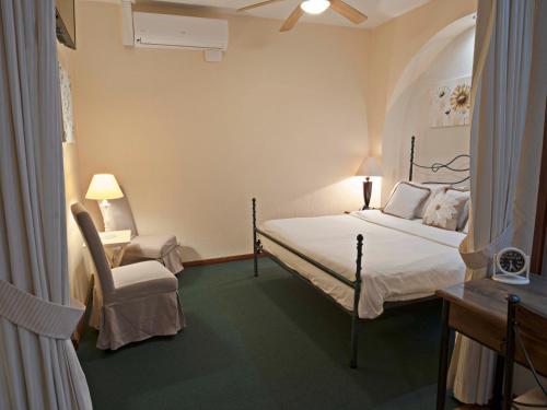 a bedroom with a bed and a chair and a desk at Fleur de Lys in San José