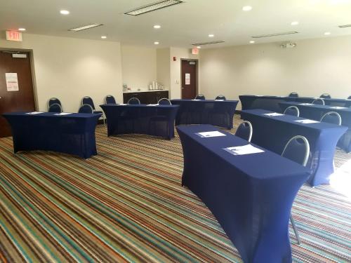 a room with blue tables and chairs on a carpet at Holiday Inn Express Hotel & Suites Mebane by IHG in Mebane