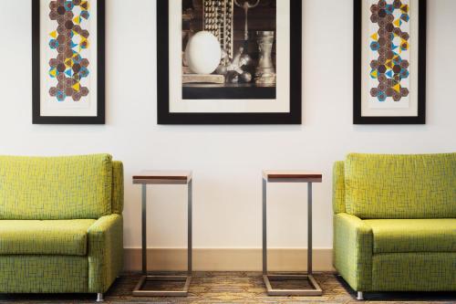two green chairs in a room with pictures on the wall at Holiday Inn Express & Suites - Middletown - Goshen by IHG in Middletown