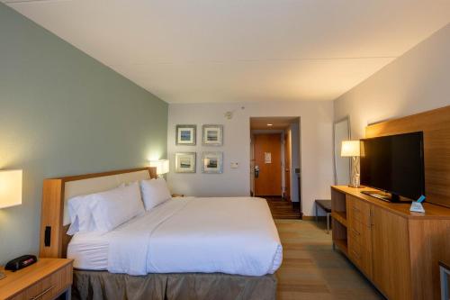 a hotel room with a bed and a flat screen tv at Holiday Inn Manahawkin/Long Beach Island by IHG in Manahawkin