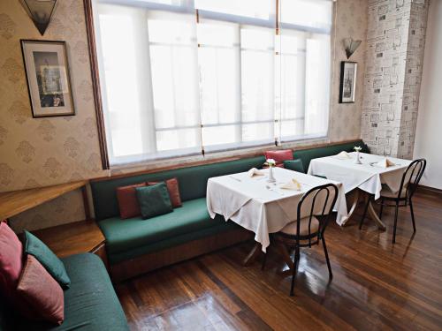 a restaurant with two tables and a green couch at Fleur de Lys in San José