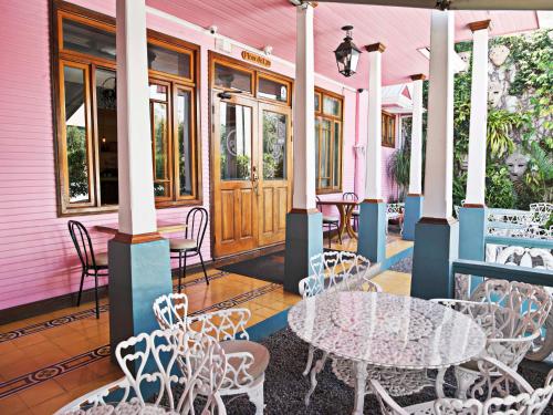 a pink building with tables and chairs on a patio at Fleur de Lys in San José