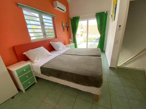 ein Schlafzimmer mit einem Bett mit einer orangefarbenen Wand in der Unterkunft Heliemar in Lagun